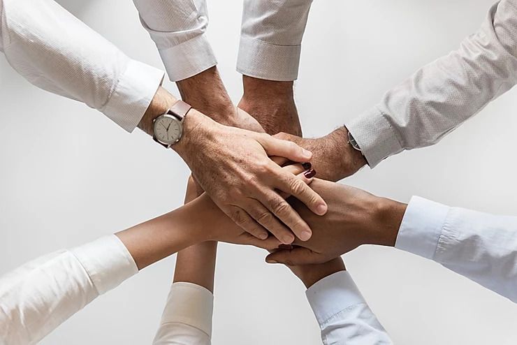 Co-worker's hands in a team huddle