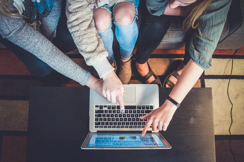 People pointing at a laptop monitor